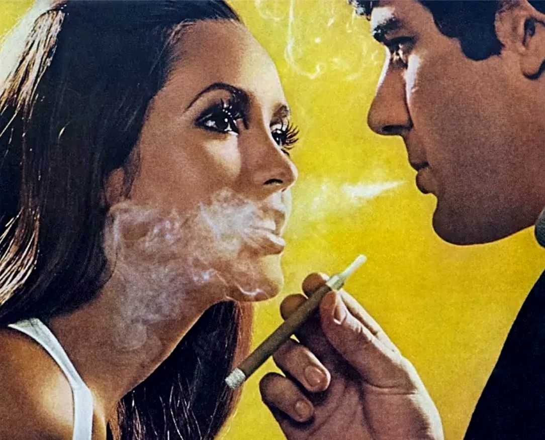 a man blowing smoke into a woman's face